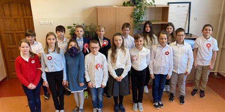 Powiększ grafikę: Grupa dzieci klasy 5a ubrana na galowo śpiewa "Mazurka Dąbrowskiego"
