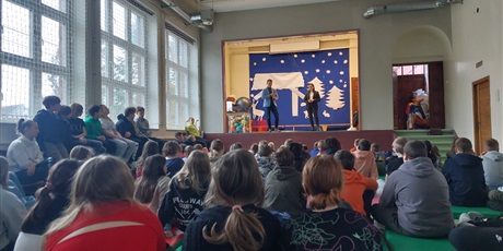 Powiększ grafikę: prelegenci stoją na scenie i odpowiadają na pytania dzieci siedzących pod sceną.