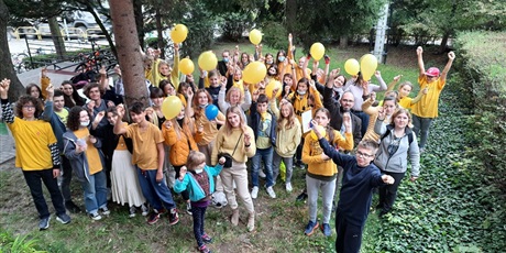 Powiększ grafikę: Uczniowie na żółto ubrani machają żółtymi balonami. 