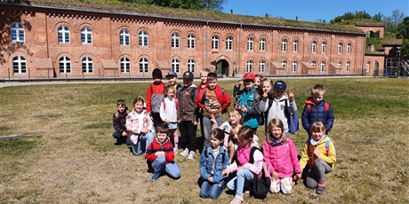 Powiększ grafikę: Dzieci z klasy pierwszej pozują do zdjęcia przed budynkiem Hevelianum