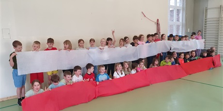 Powiększ grafikę: Grupa dzieci trzyma polską flagę