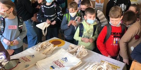 Powiększ grafikę: uczniowie oglądają torby ekologiczne przygotowane na pomoc Ukrainie 