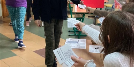 Powiększ grafikę: Uczniowie odbierają karty do głosowania.